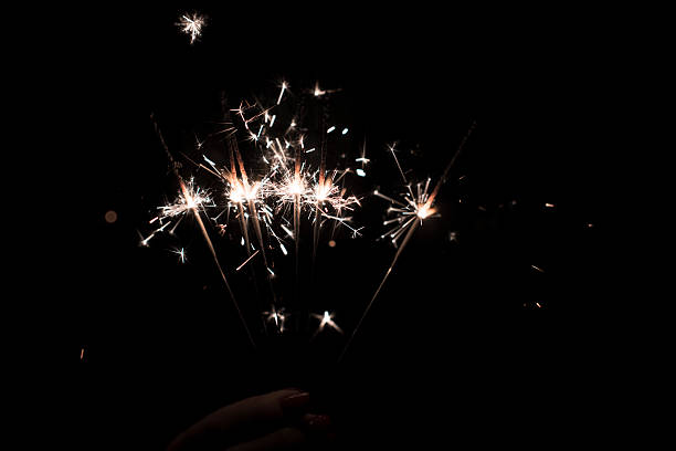feiern die feiertage - sparkler sparks new years eve human hand stock-fotos und bilder