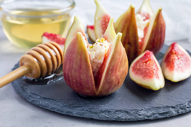 istock Figs, cheese, pistachio and honey dessert on slate plate, horizontal 601130988