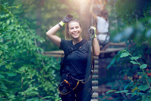 happy young woman wearing protective equipment, ready for her adventure in the forest, natural park.