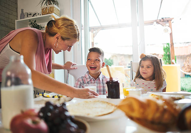 istock happy mother and kids having breakfast in kitchen 601133810