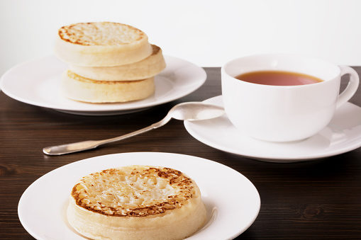 Tea and crumpets on a dark wooden table