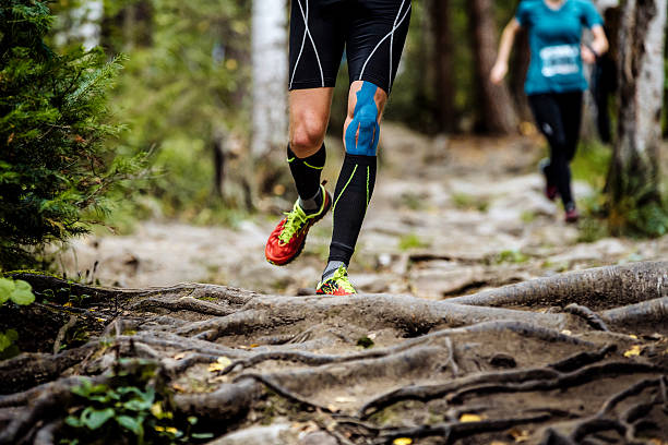 бег марафонец в лесу - kinesio стоковые фото и изображения