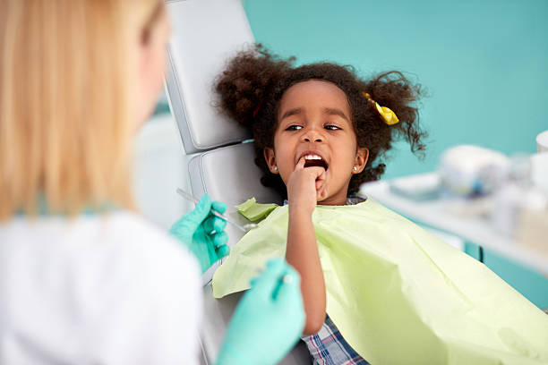 istock Black girl shows with finger aching tooth 601140062