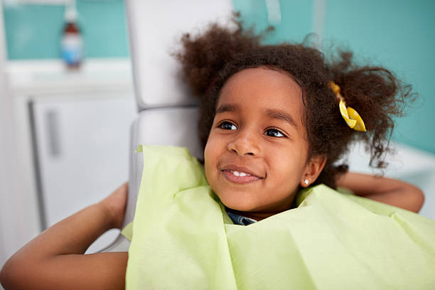 Portrait of satisfied child after dental treatment Portrait of satisfied child in dental chair after successful dental treatment dental equipment photos stock pictures, royalty-free photos & images