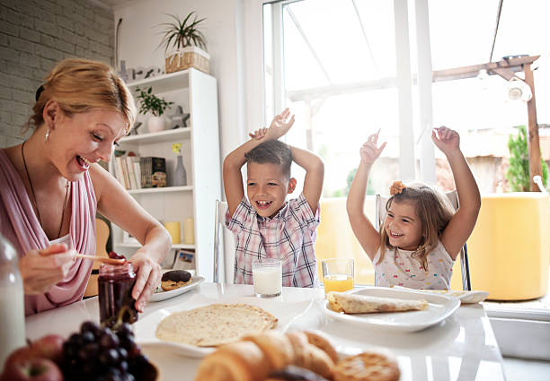 istock happy mother and kids having breakfast in kitchen 601141422