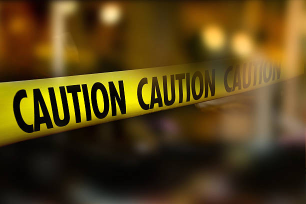 istock Caution tape and blurred law enforcement and forensic background 601141512