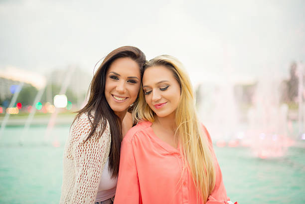 Girlfriends having fun while walking on the sidewalks of downtown