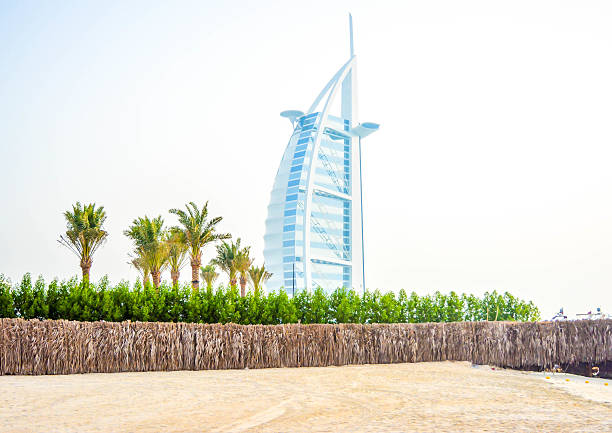Marvel at the stunning Dubai skyline behind the Persian Gulf, featuring the iconic Jumeirah Marsa Al Arab Hotel and Burj Al Arab, epitomizing luxury and architectural brilliance. In front the Jumeirah Beach.