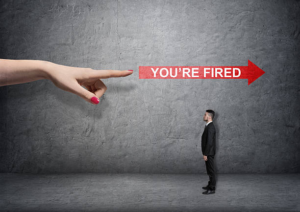 Big female arm pointing at red arrow with 'you're Big female arm pointing at red arrow with 'you're fired words' over small businessman. Boss and subordinate. Unemployment. Losing a job. autocratic leadership stock pictures, royalty-free photos & images