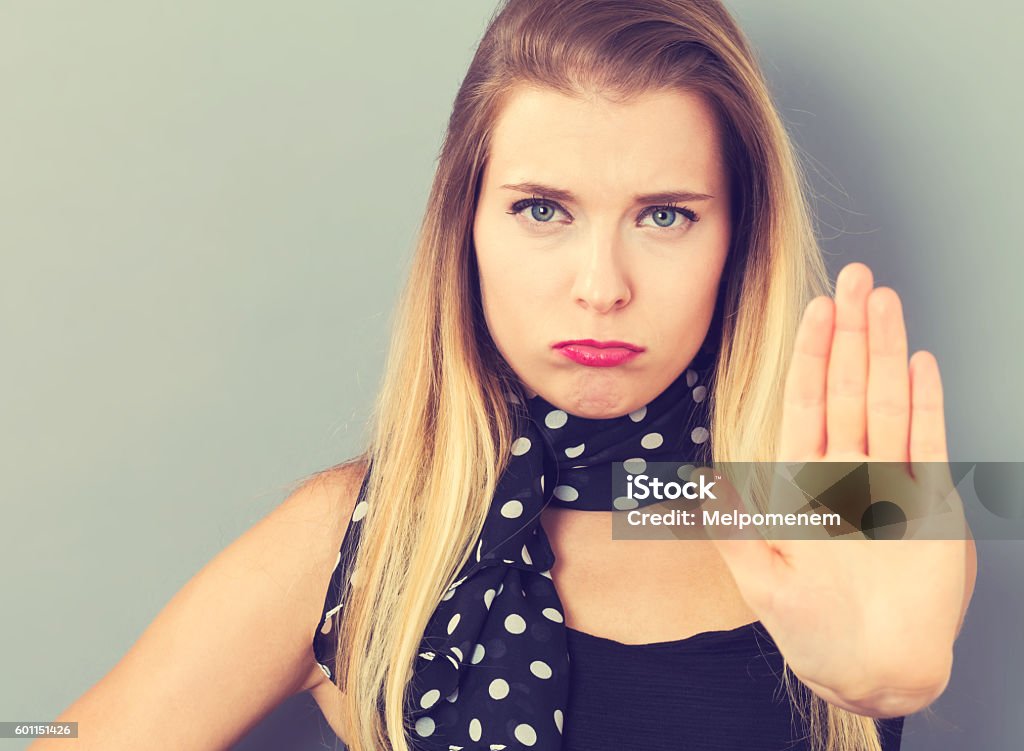 Young woman making a rejection pose Young woman making a rejection pose on a gray background Single Word No Stock Photo