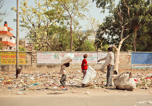 Jaipur, India - January 21, 2015: Unidentified children with poor father clean out debris for further recycling process on January 21, 2015. Jaipur, with population 6,664,000 people, is a capital of Rajasthan