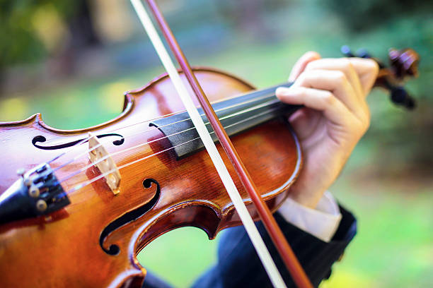 Man playing violin Unrecognizable Caucasian man playing violin outdoors. violinist photos stock pictures, royalty-free photos & images