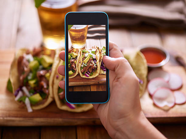 taking photo of street tacos with smartphone taking photo of street tacos with smartphone flatbread photos stock pictures, royalty-free photos & images