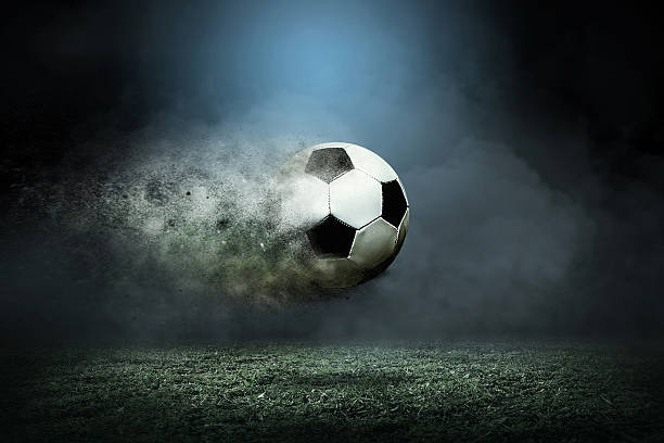 istock Moving soccer ball around splash drops on the stadium field. 601357874