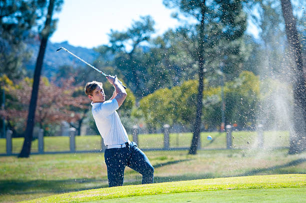 istock golfer playing a chip shot onto the green 601362296
