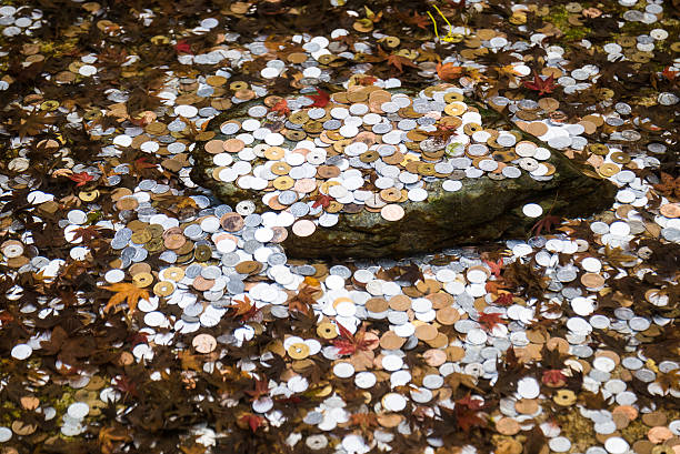 A bunch of Japanese coins lying on the bottom of a fountain.