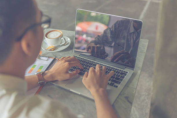 istock Young businessman transferring information from sales reports to laptop 601366710