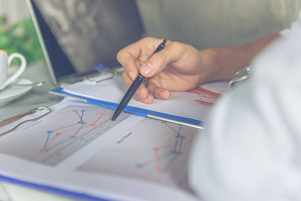istock Asian office employee checking sales report at workplace 601367076