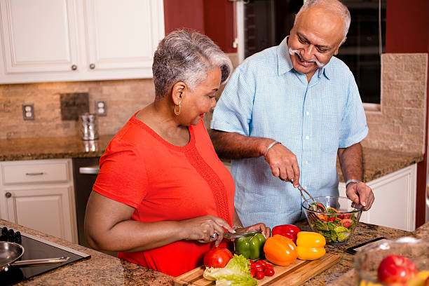 feliz pareja de adultos mayores cocinando juntos en la cocina de casa. - cooking senior adult healthy lifestyle couple fotografías e imágenes de stock