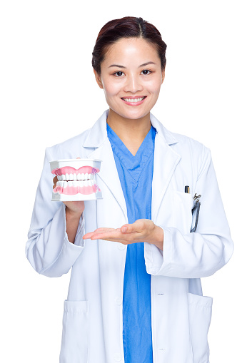 Female dentist holding dentures