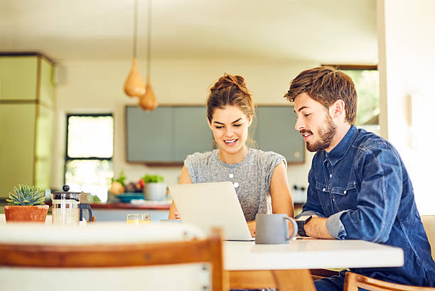 istock Happy young man and woman using laptop at table 601370748