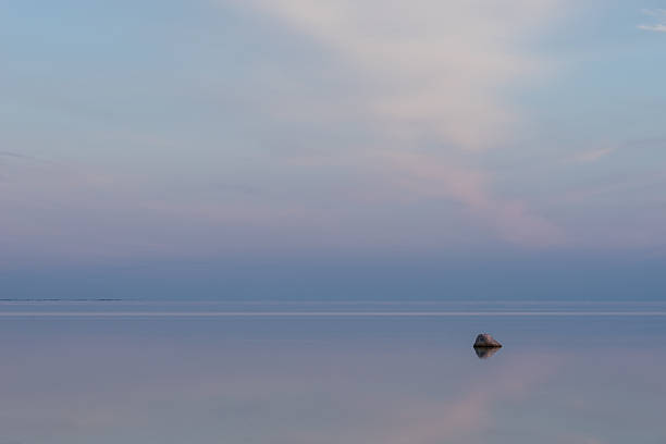 istock Evening sunlight on coast. Pink clouds, blue sky reflection seaside 601372582