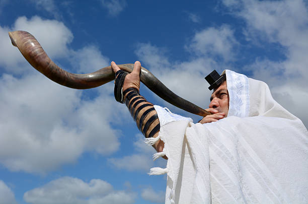 Jewish man blow Shofar Jewish man blow Shofar outdoors under the sky, on the Jewish High Holidays in Rosh Hashanah and Yom Kippur wind instrument stock pictures, royalty-free photos & images