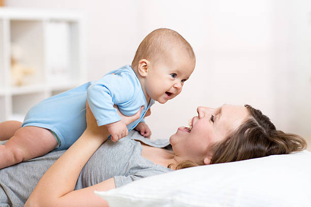 istock Happy mother playing with adorable baby 601378838