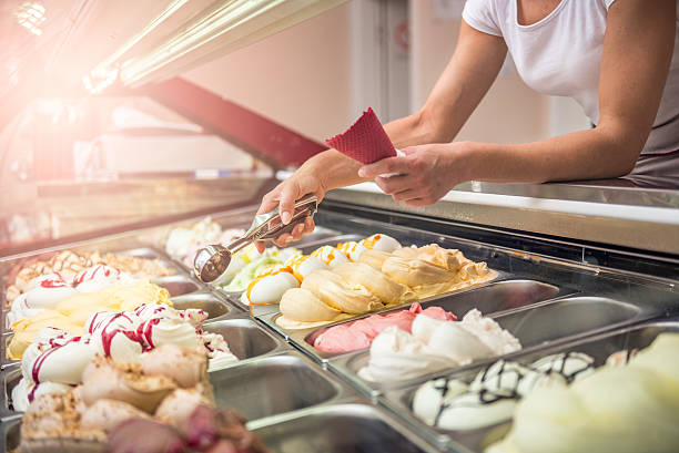 Woman serving ice cream Woman serving ice cream in Confectionery shop serving utensil stock pictures, royalty-free photos & images