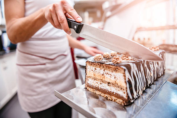 istock Pastry chef taking slice of cake 601379258