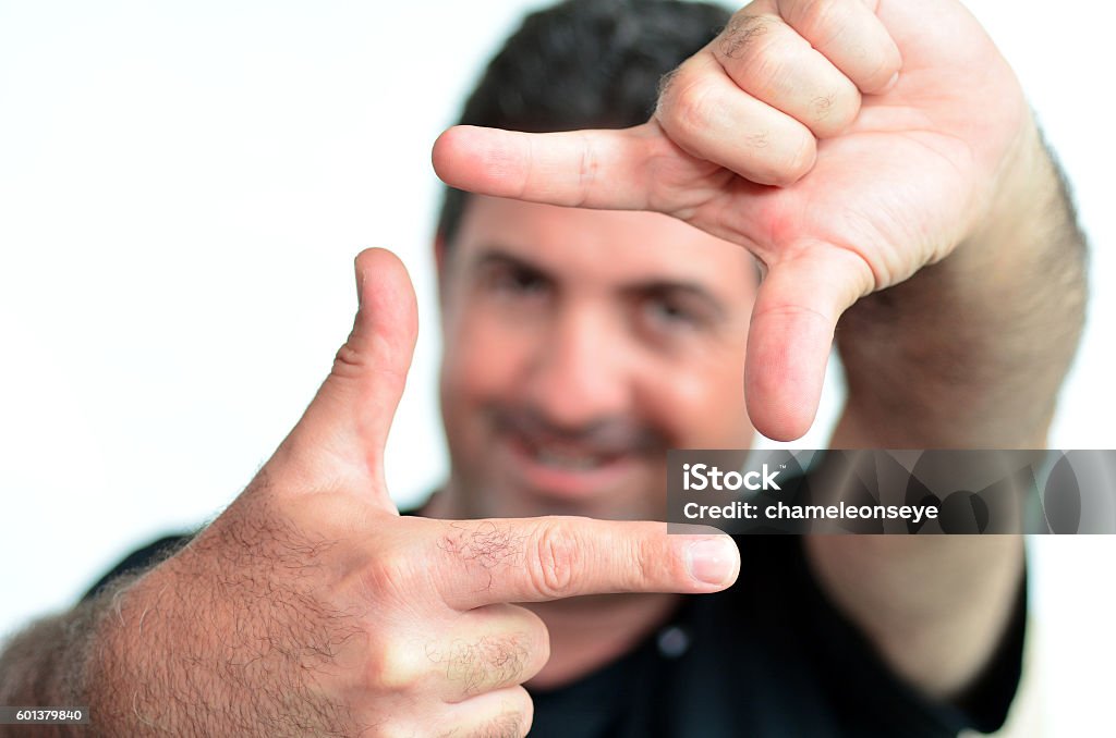 Happy mature man creating frame with fingers Happy one young mature man only creating frame with fingers.Copy space on white background. real people. Concept photo of cool, creative, confident,  aspirations, manly, man. Accuracy Stock Photo