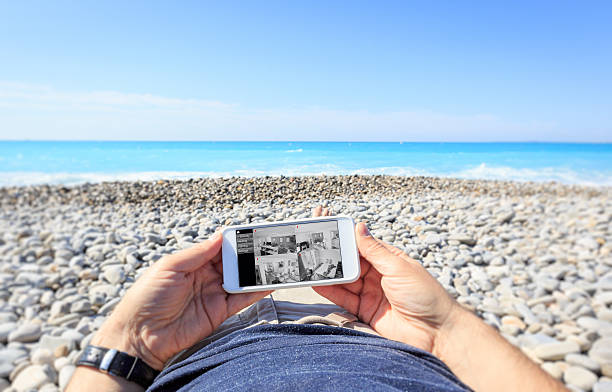 tourist at the beach checking surveillance cameras at home - nice looking imagens e fotografias de stock