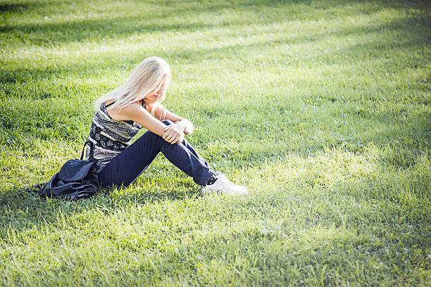 istock Young woman with long hair resting on the grass. 601381276