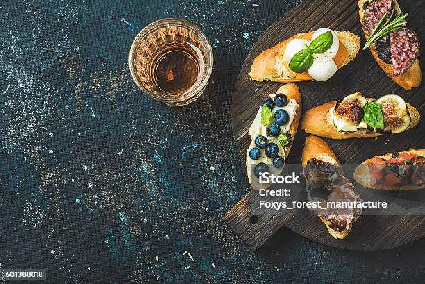 Italian Crostini And Glass Of Rose Wine Over Dark Background Stock Photo - Download Image Now