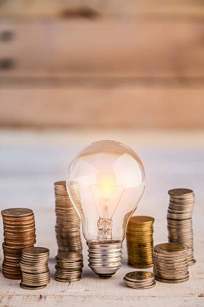 istock White light bulb among many coins heap 601389738
