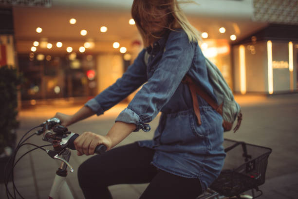 Young woman riding the bicycle around the city 