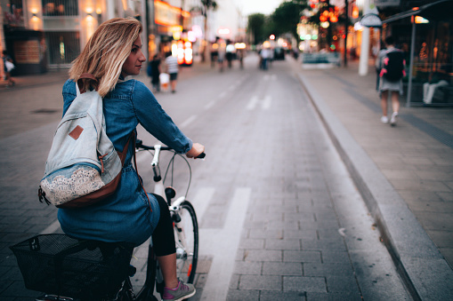 Young woman riding the bicycle around the city 