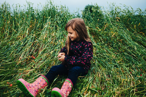 Little cute toddler girl at the Ballybunion surfer beach, having fun on with playing on west coast of Ireland. Happy child enjoying Irish summer and sunny day with family