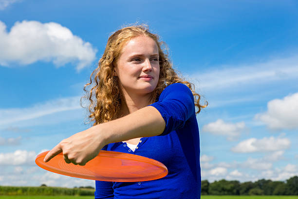 jovem holandesa jogando frisbee laranja - plastic disc ultimate competition determination - fotografias e filmes do acervo
