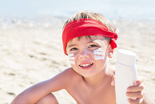 istock Who am I? Sunscreen (suntan lotion) is on boy face. 601397666