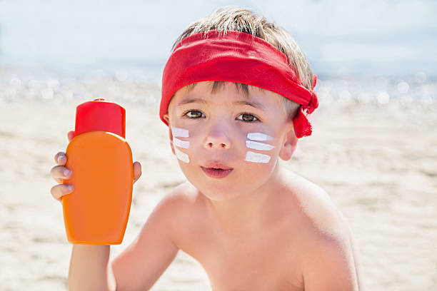 istock Who am I? Sunscreen (suntan lotion) is on boy face. 601398386