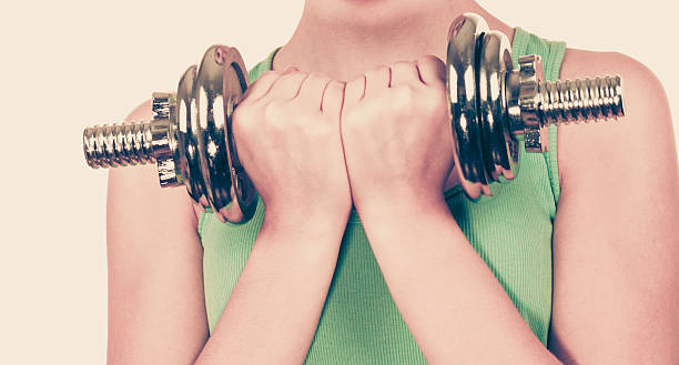 istock Woman exercising with dumbbells lifting weights 601398430