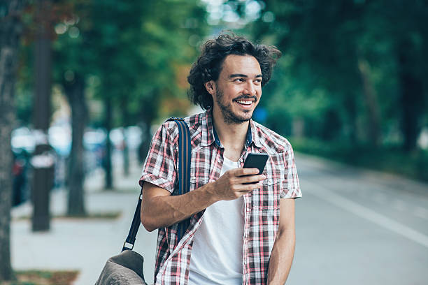 istock Young man texting outdoors in the city 601400838