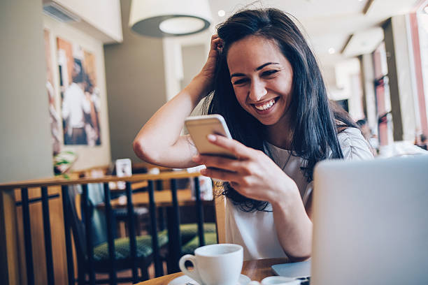istock Young woman with smart phone in cafeteria 601401436