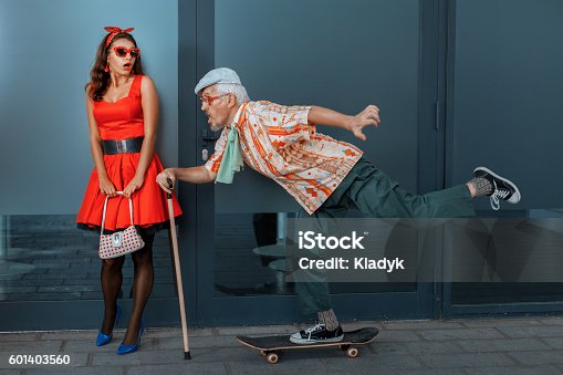 istock Old man quickly rides a skateboard on the street. 601403560