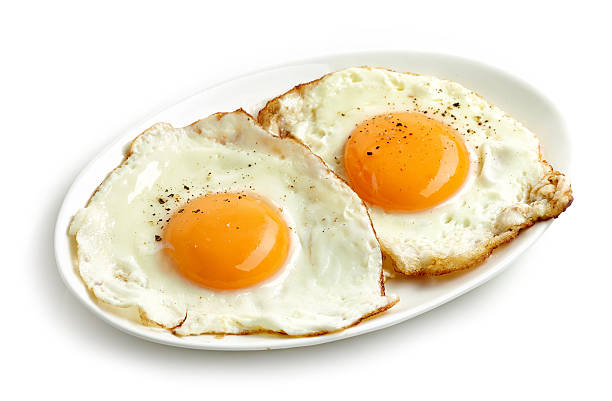 fried eggs on white background stock photo