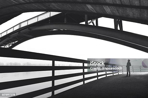 Man Standing Under Bridge Arch Stock Photo - Download Image Now - Architecture, Black And White, People