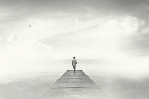 istock Man walking on a boardwalk in the fog 601897660