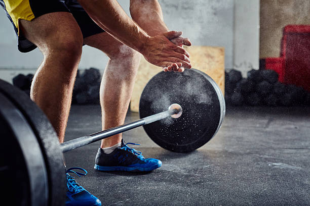 istock Weightlifter clapping hands before workout with barbell at the g 601902480
