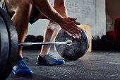 Closeup of weightlifter clapping hands before  barbell workout a